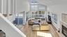 Living area with a tile fireplace, light wood-type flooring, plenty of natural light, and high vaulted ceiling