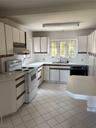 Kitchen with white cabinetry, range, and light countertops