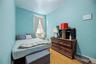 Sloped ceiling room featuring wood-finish flooring, a double window, and a flush-mount light fixture