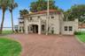 Mediterranean lakefront estate on Lake Harris with clay barrel tile roof and brick paver circular drive