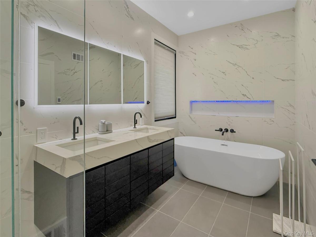 Full bathroom on first floor with double vanity, shower and soaking tub and separate shower