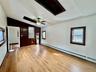 2 - Unfurnished room with lofted ceiling, wood 3 - finished floors, a ceiling fan, and a baseboard radiator
