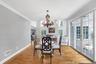 Hardwood flooring throughout, elegant crown molding, double French doors with transom windows, and a chandelier light fixture and access to outdoor pa