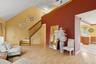 Living area with light wood-style flooring, stairway, and high vaulted ceiling
