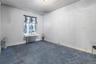 Carpeted spare room featuring radiator heating unit and baseboards