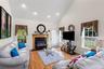 Living room featuring high vaulted ceiling, hardwood / wood-style flooring, a fireplace with flush hearth, and recessed lighting