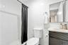 Bathroom with vanity, a shower stall, and tile walls