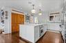 Kitchen featuring white cabinets, light countertops, ornamental molding, and stainless steel oven