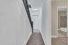 Hallway featuring stairway and light colored carpet