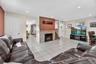 Living area featuring light tile patterned floors, recessed lighting, and a fireplace