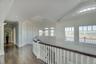 Hall featuring healthy amount of natural light, ornamental molding, dark wood-type flooring, vaulted ceiling, and recessed lighting