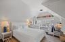 Bedroom featuring visible vents, vaulted ceiling, and wood finished floors