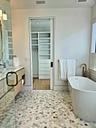 Bathroom featuring a freestanding bath, a spacious closet, visible vents, and a stall shower