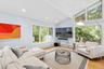 Living room with a baseboard heating unit, light wood-style flooring, and recessed lighting