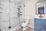 Full bath with vanity and a marble finish shower