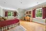 Bedroom with crown molding, light wood-style floors, and vaulted ceiling