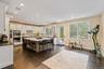 Kitchen featuring a breakfast bar, light stone counters, white cabinetry, dark wood-style flooring, and a kitchen island