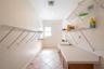 “Spacious indoor laundry room featuring a utility sink, lower cabinetry for organized storage, and additional wired shelving