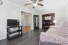 Living area with dark wood-finish flooring and a ceiling fan