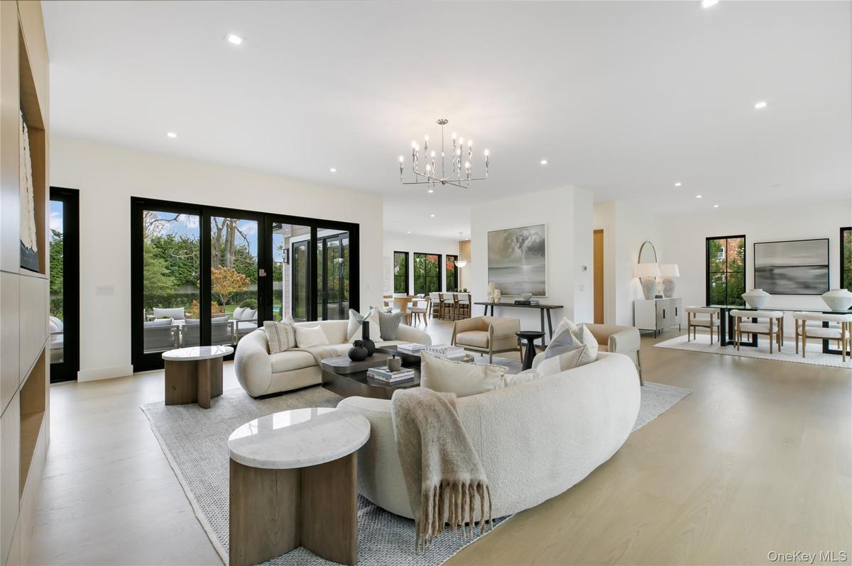 Living room featuring recessed lighting, a chandelier, plenty of natural light, and light wood-style flooring