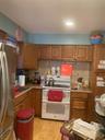 Kitchen featuring brown cabinets, black range, refrigerator, and recessed lighting