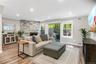 Spacious living room with wood burning fireplace and sliders to deck
