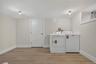 Dedicated laundry area featuring a washer and dryer, wood-finish flooring, and a window for natural light