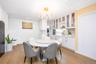 Dining room with stacked washer and clothes dryer, light wood-style floors, a chandelier, crown molding, and recessed lighting