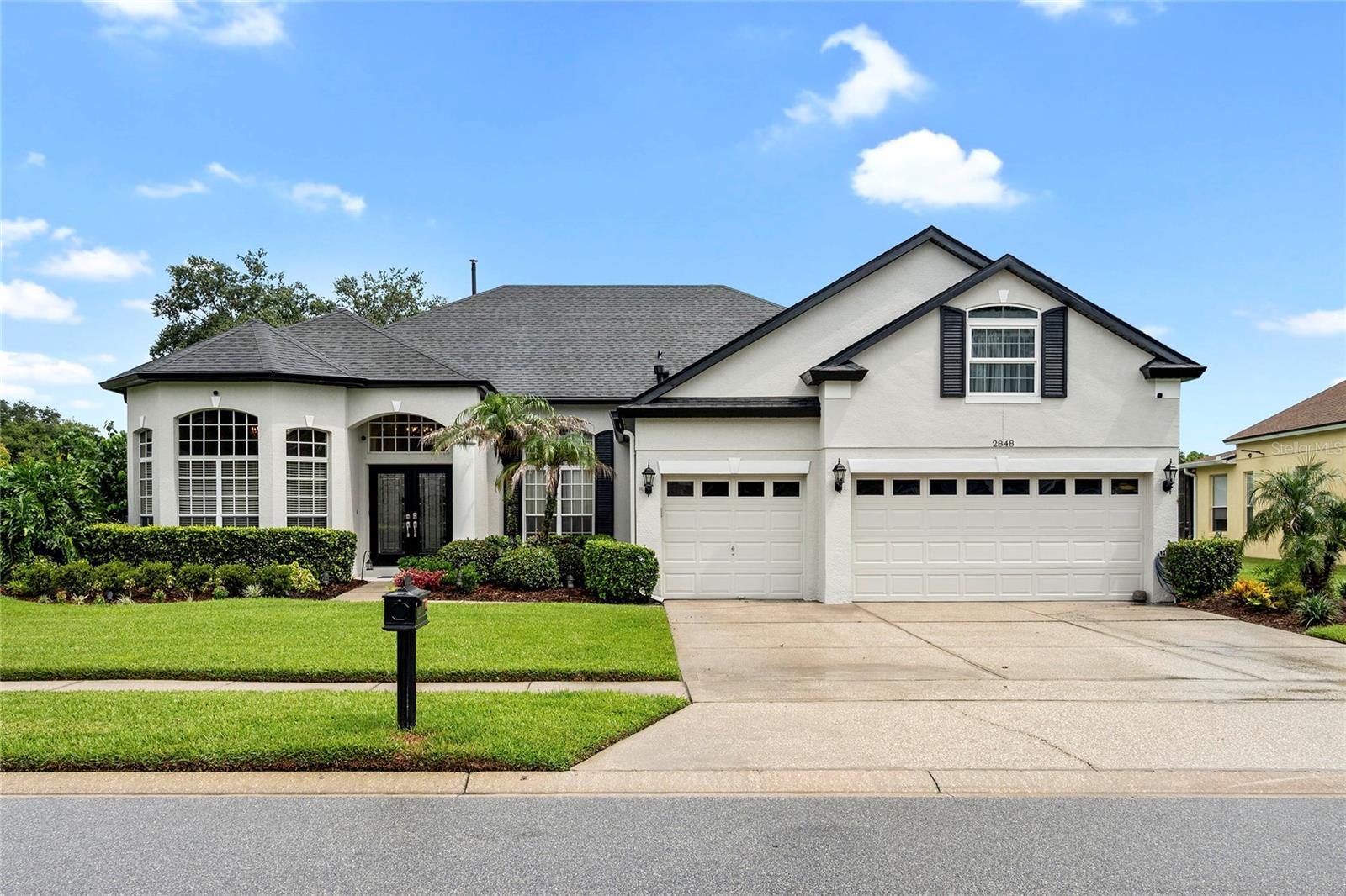 front with mature landscape and 3 car garage