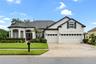 front with mature landscape and 3 car garage
