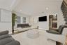 Spacious living area featuring dark wood-finish flooring, recessed lighting, and white walls