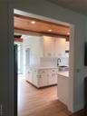 Kitchen featuring light wood finished floors, white cabinets, wooden ceiling, light countertops, and a sink