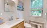 Bathroom featuring radiator, tile walls, vanity, walk in shower, and toilet