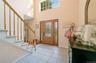 Entrance foyer featuring a towering ceiling, stairs, light tile patterned floors, baseboards, and a baseboard heating unit