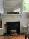Interior details featuring ceiling fan, a fireplace, and wood finished floors