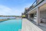 Swimming pool with area for grilling, a water view, a ceiling fan, a patio area, and a sink