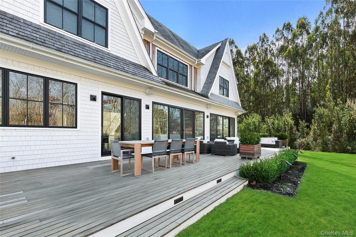 Wooden deck featuring an outdoor living space, outdoor dining area, and a lawn