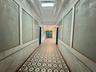 Hallway featuring a decorative wall, a textured wall, and ornamental molding