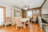 Dining area featuring wood-finish flooring, wood paneling, and a ceiling fan with integrated lighting