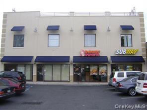 View of building exterior with uncovered parking