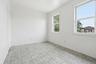 Room with light-toned tiled flooring and white painted walls