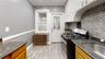 Kitchen with radiator heating unit, tasteful backsplash, sink, stainless steel gas range oven, and light hardwood / wood-style flooring