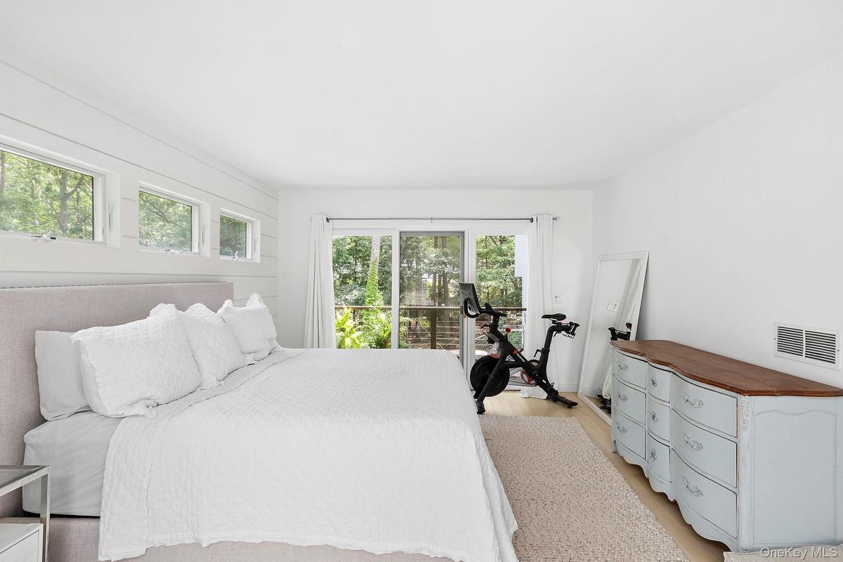 Bedroom with access to exterior, light hardwood / wood-style flooring, and multiple windows