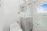 Full bathroom featuring tile walls, vanity, and bath / shower combo with glass door