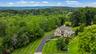 Aerial view of home with lush landscaping privacy and mountains in the backdrop