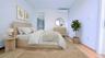 Bedroom featuring a walk in closet, a wall mounted air conditioner, and light wood-style flooring