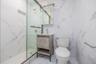 Bathroom featuring marble look tiles, a marble finish shower, and vanity