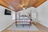 Bedroom featuring vaulted ceiling, wood ceiling, ceiling fan, and light wood-style floors