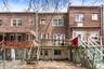 Rear view of house featuring brick siding, stairs, and a deck