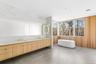 Full bath with a freestanding bath, double vanity, concrete floors, and wood walls